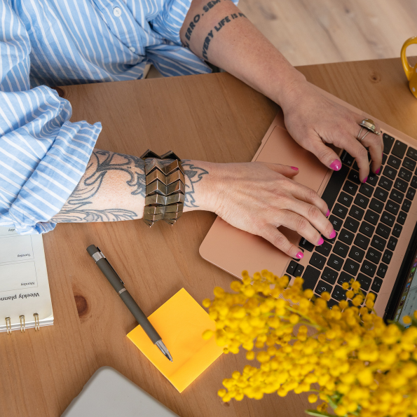 Woman types at her computer on her kitchen table